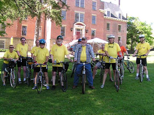 group of bicyclists in front of a brick building